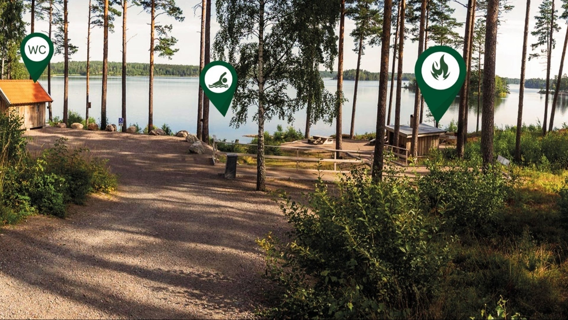 En naturbild med flera grafiska infopins som visar badplats, wc och eldplats.