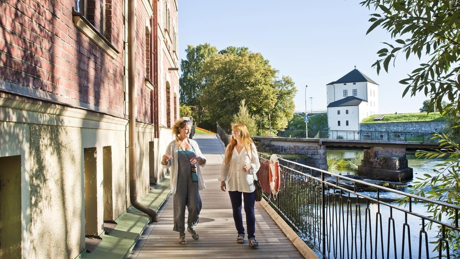 Två kvinnor som går längs med Nyköpingsån